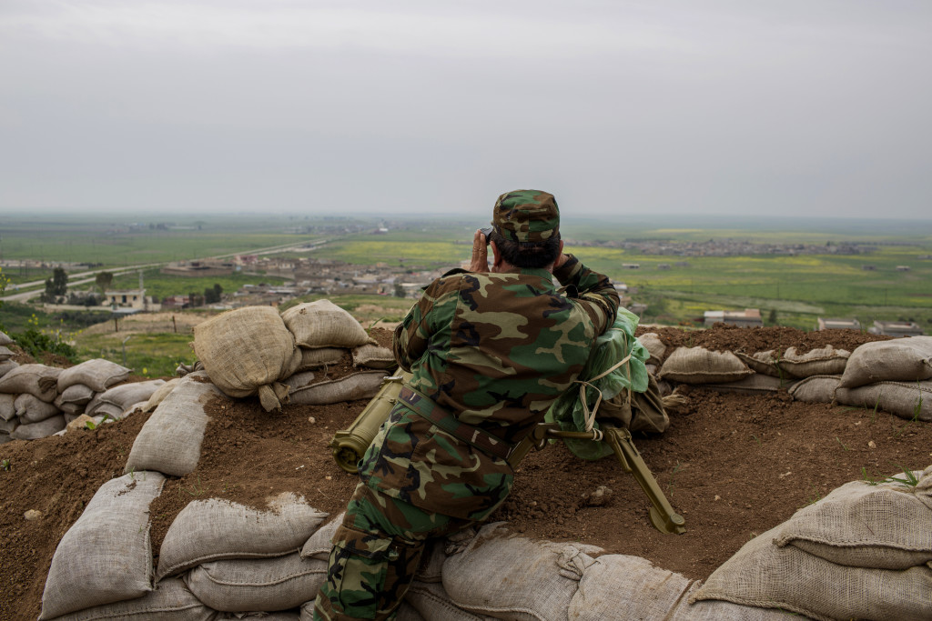 Talesskef, Irak. En Peshmerga-soldat håller utkik efter IS som är i byn nedanför. 